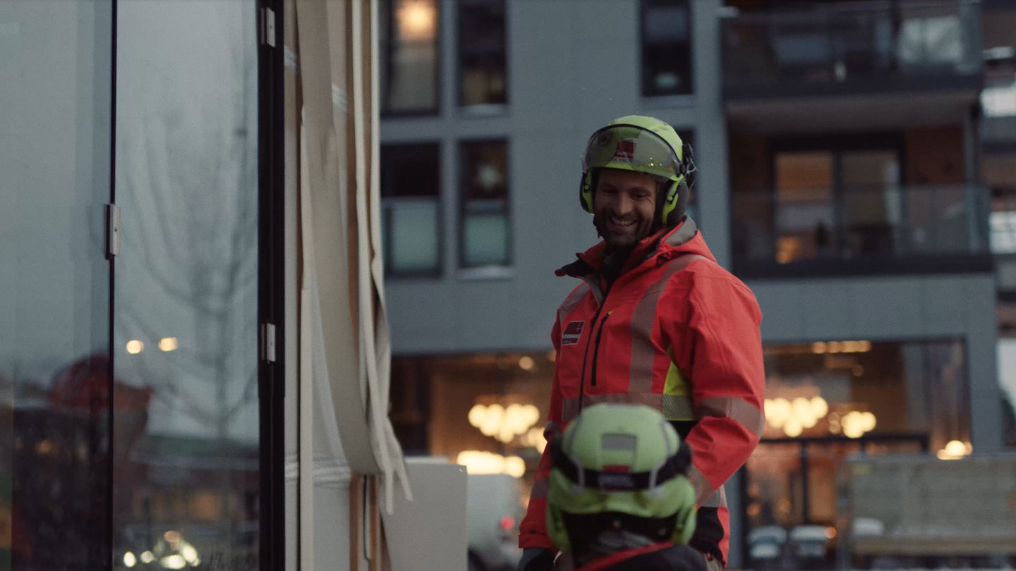 Mann på byggeplass i samtale. Foto. 