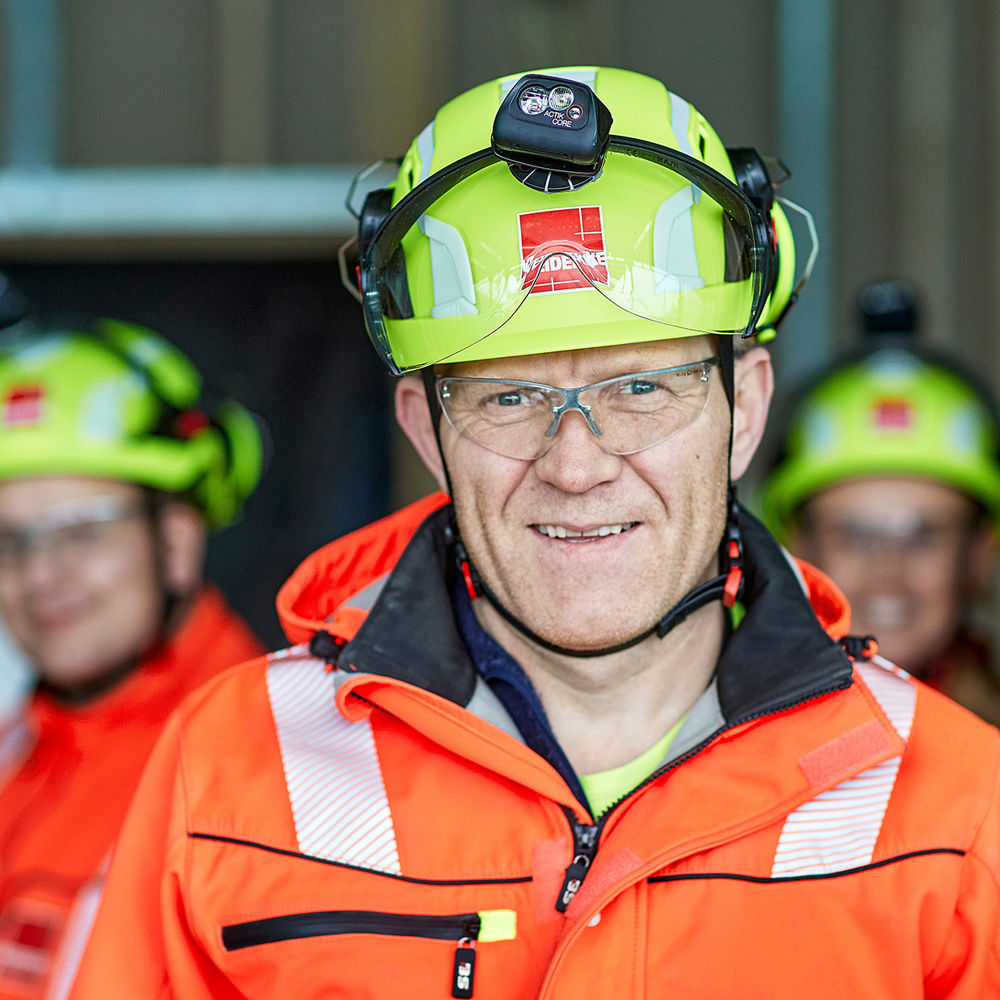 Gruppe mennsker med hjelm og i synlighetstøy. Foto.