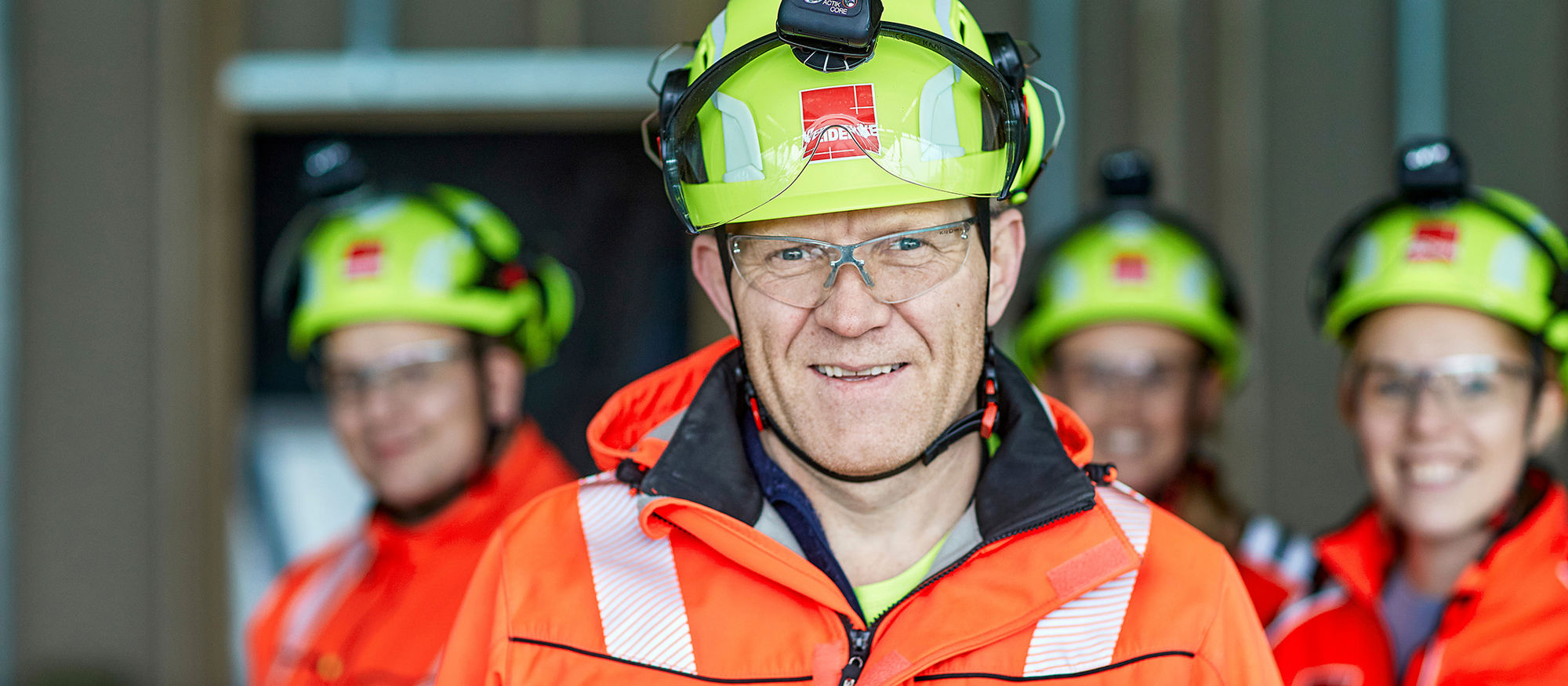 Gruppe mennsker med hjelm og i synlighetstøy. Foto.