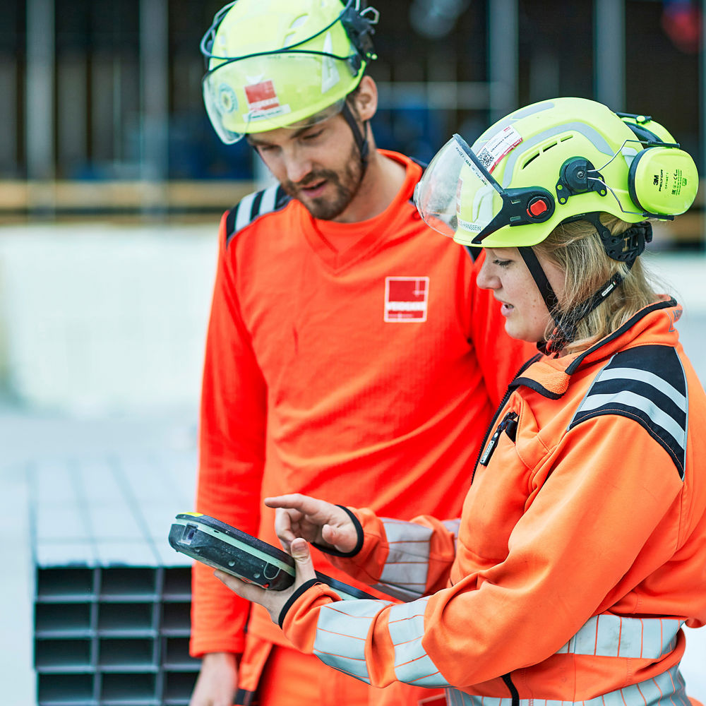 Kvinne og mann samhandler på digitalt, byggeplass. Foto.