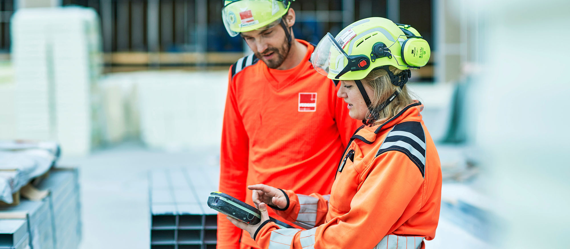 Kvinne og mann samhandler på digitalt, byggeplass. Foto.