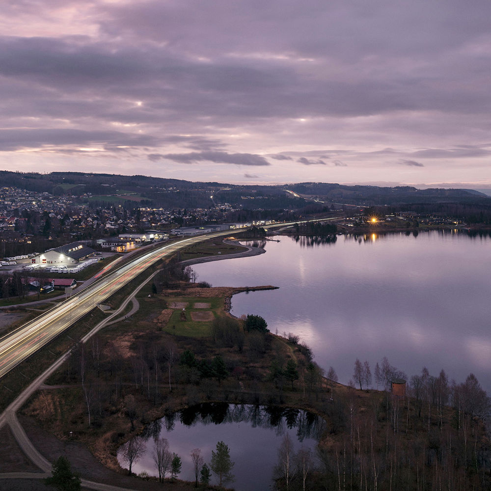 Utsikt over E6 og Mjøsa ved Brumunddal i skumringstimen. Foto.