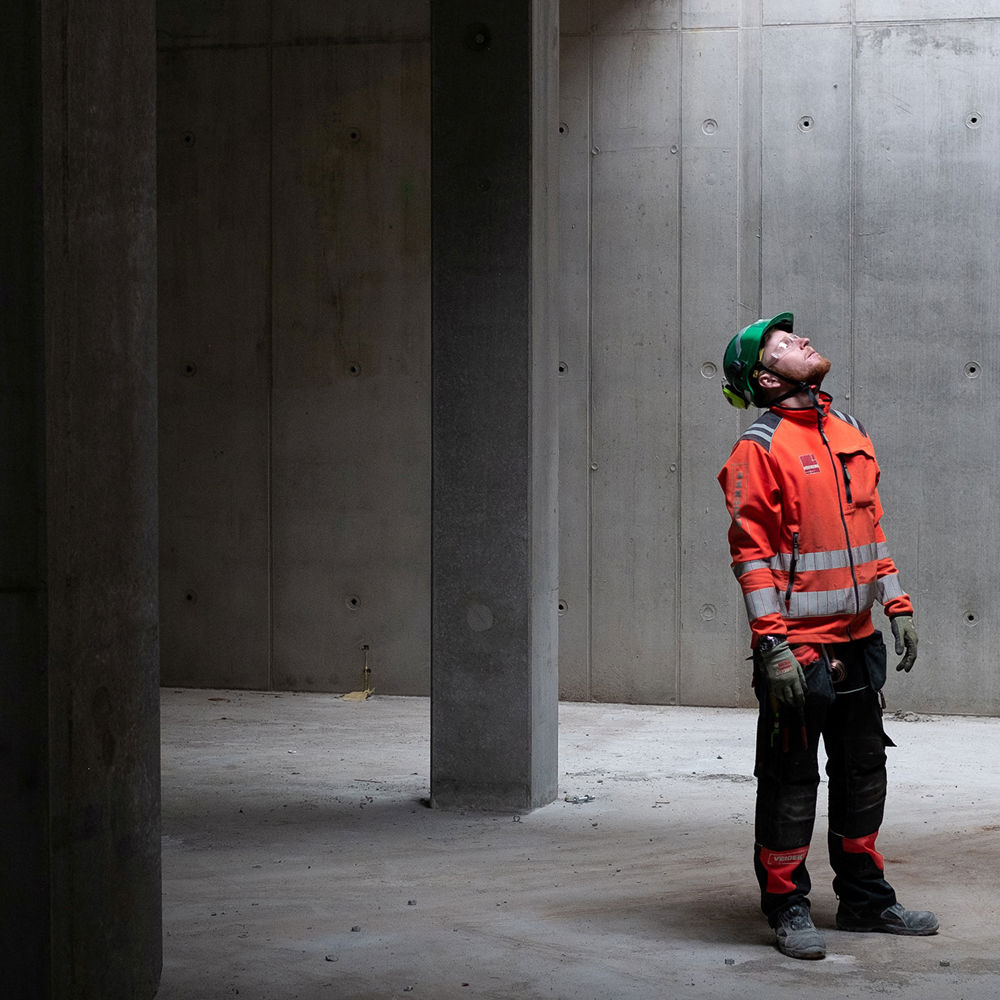 Mann i bygg med betongvegger. Foto.