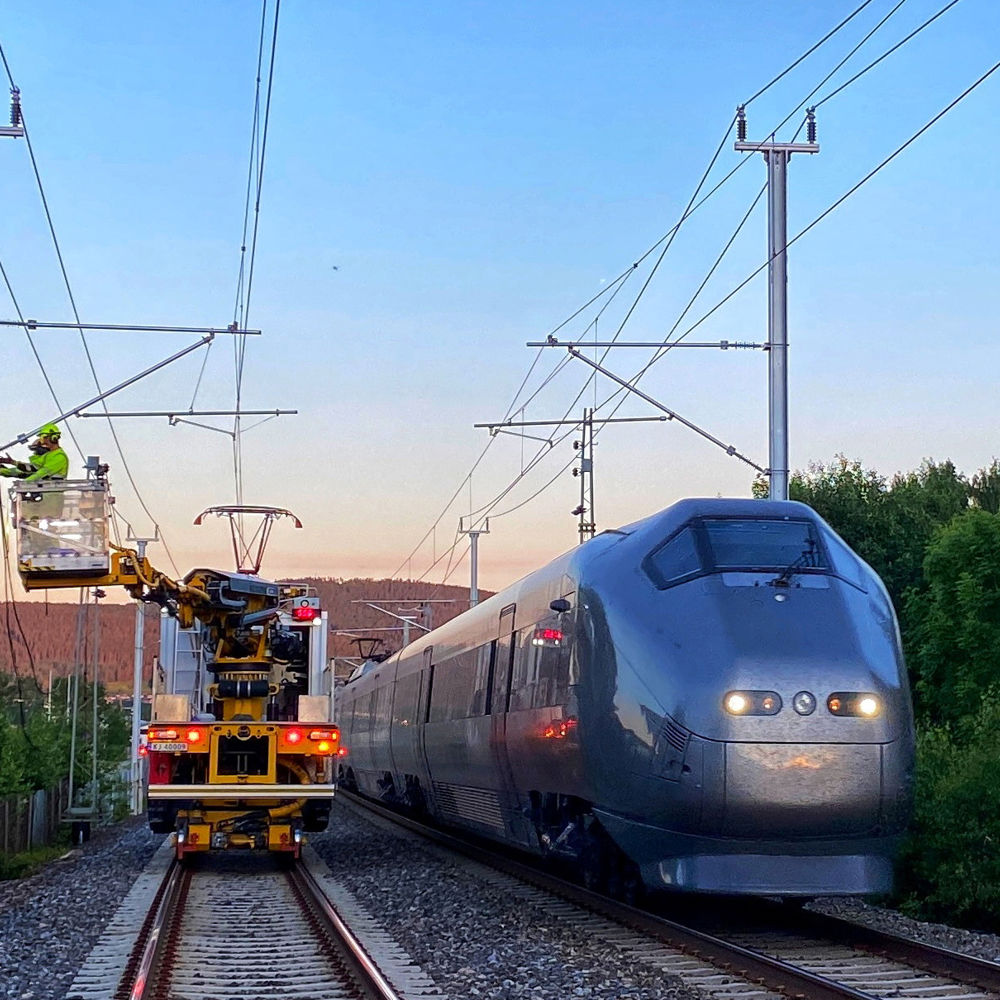 Arbeid med kjøreledning. Flytoget på nabosporet. Foto.